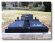 High Black Monument with Large Blue Pearl Headstone, Ledgers and Vases